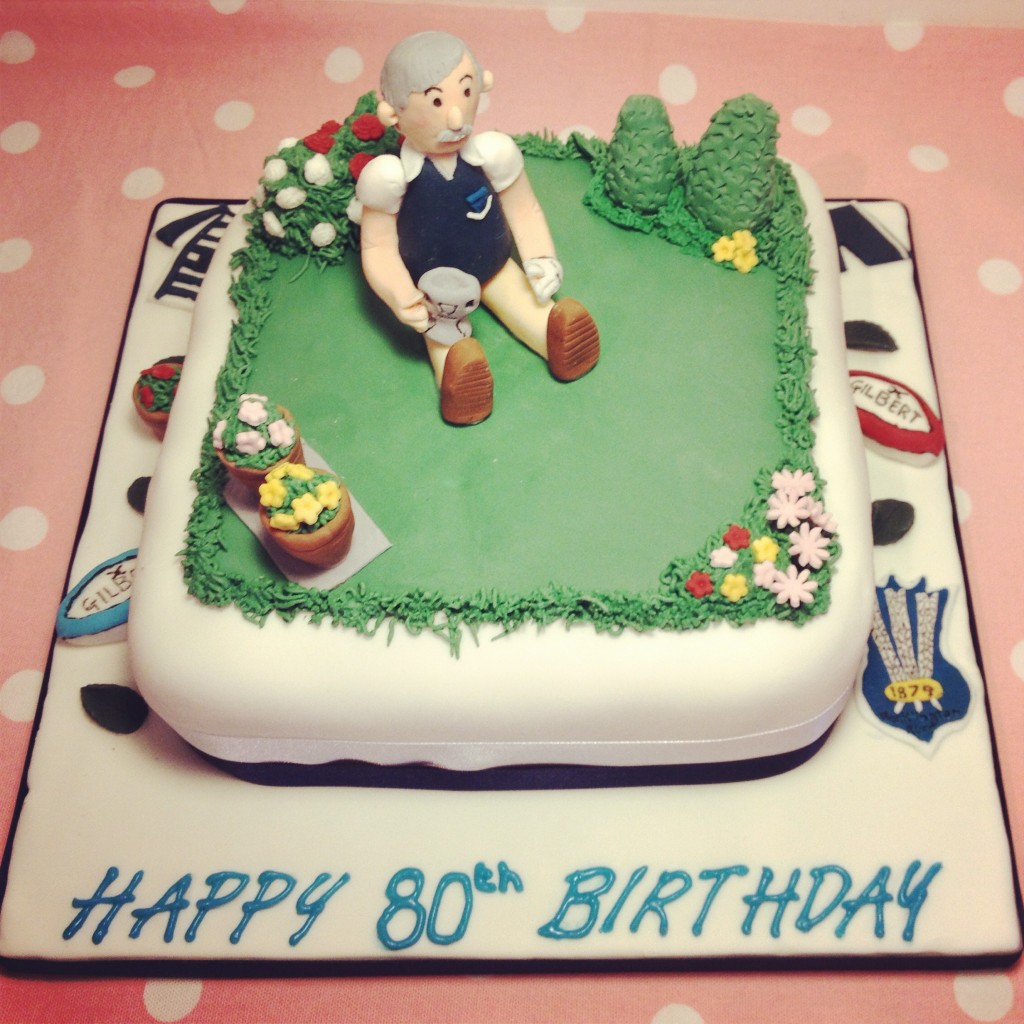 Garden themed cake, with rugby and golf elements.
